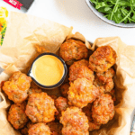Pinterest image of an overhead shot of a bowl of Cheddar Bay Sausage Balls with spicy mayo dip on the side.