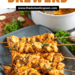 Pinterest image of Garlic Parmesan Chicken Skewers on a platter with parsley behind them.