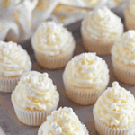 Pinterest image of wedding cupcakes piped with buttercream frosting on a baking tray.