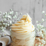 Pinterest image of a small glass jar piped to overflowing with brown butter cream cheese frosting.