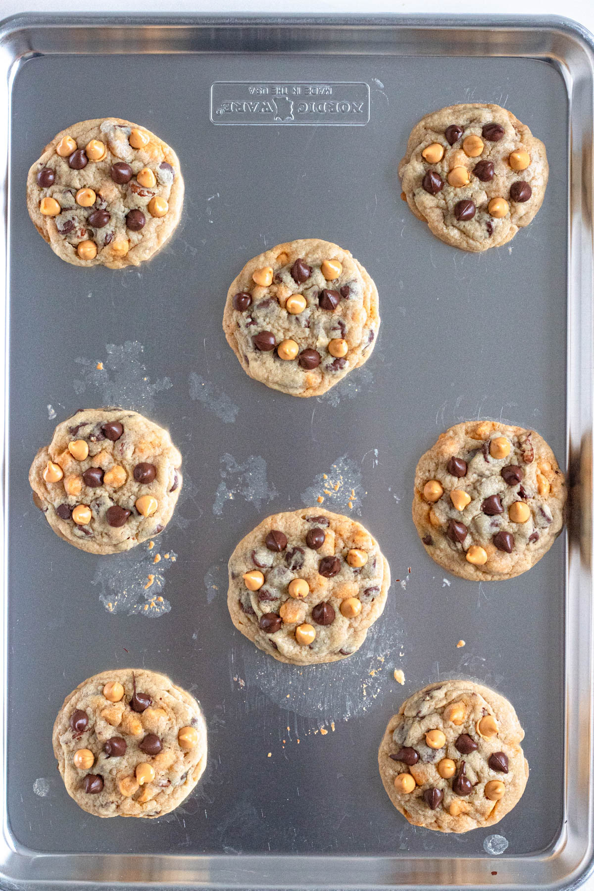 Chocolate chip and butterscotch chip cookies on a cookie sheet.