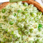 Pinterest image of a close-up, overhead shot of creamed peas in a bowl.