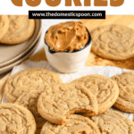 Pinterest image of a small bowl of creamy peanut butter next to a stack of freshly baked peanut butter cookies, with the top one missing a bite.