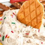 Pinterest image of a waffle cone resting in the creamy sweet Dunkaroo dip with other dippers surrounding the bowl like strawberries and graham crackers.