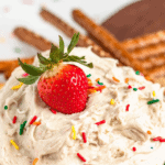 Pinterest image of a whole strawberry garnished on the top of a bowl of creamy Dunkaroo dip that's on a platter with a variety of dippers.