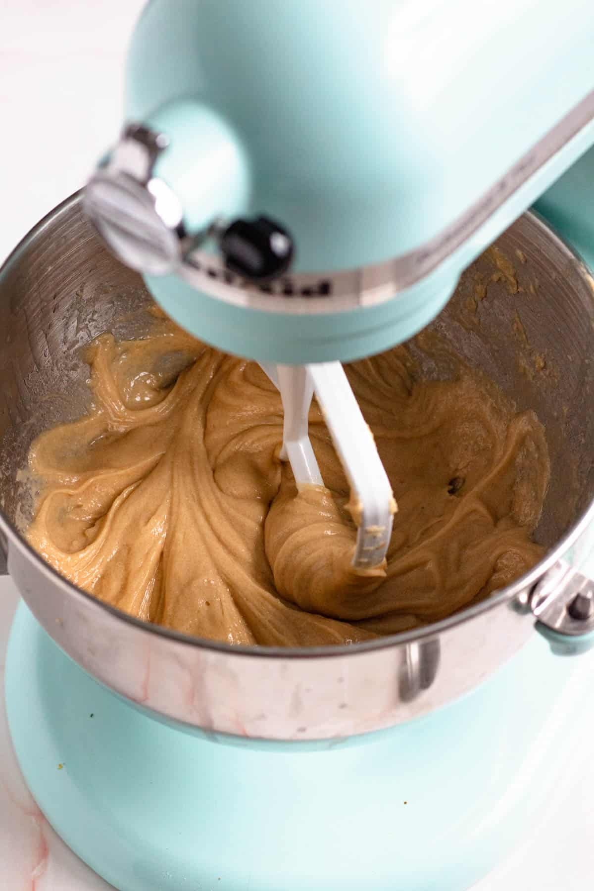 Cookie dough ingredients being combined in a mixer.