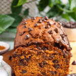 Pinterest image of chocolate chips laying around a loaf of pumpkin bread with chocolate.