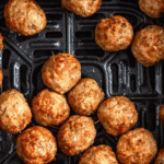 Pinterest image of an overhead shot of golden meatballs in the air fryer bucket.