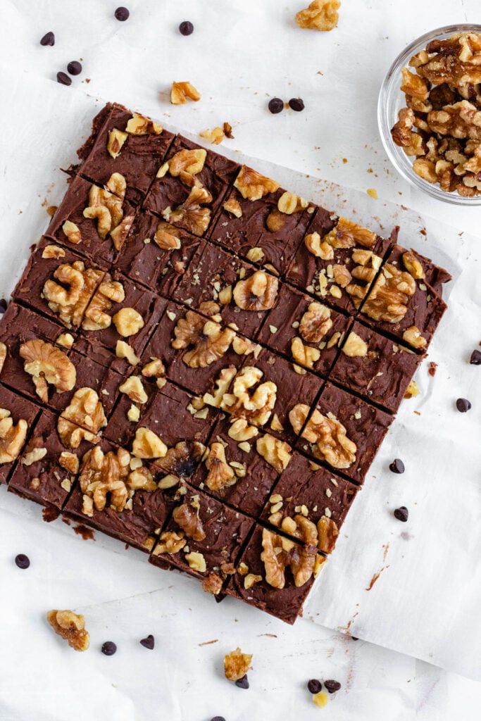 A carnation fudge cut into squares and topped with crunchy walnuts.