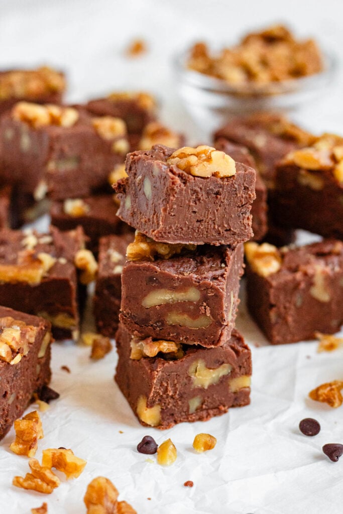 Stacked chocolate fudge squares with walnuts.
