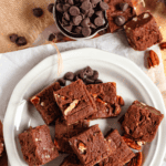 Pinterest image of an overhead shot of a plate of Velveeta Fudge with chocolate chips and pecans on the side.