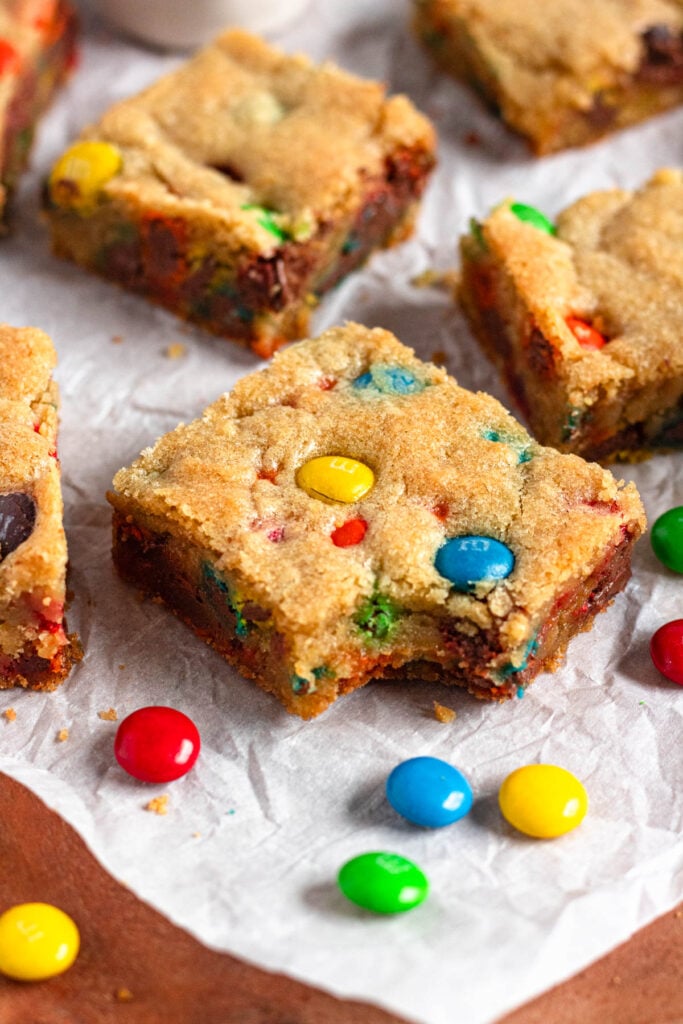 Soft & chewy M&M cookie bars with a bite taken out.