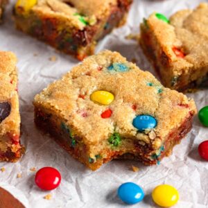 Soft & Chewy M&M cookie bars with a bite taken out.