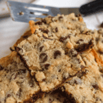 Pinterest image of a pile of chocolate chip bars with chocolate chips on the side.