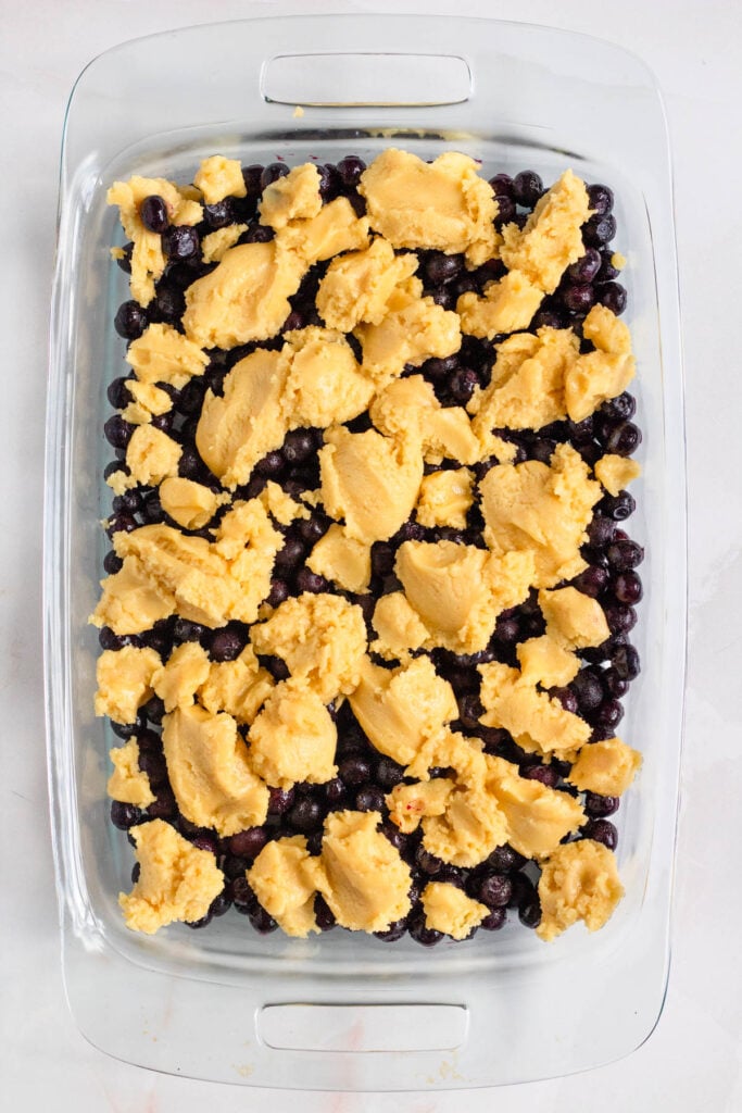 A glass pan of blueberries topped with little dollops of dough