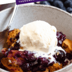 Pinterest image of 3-ingredient blueberry cobbler with a scoop of ice cream on top, with a spoon on the side.