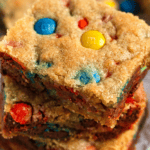 Pinterest image of a close-up shot of a stack of soft and chewy M&M cookie bars.