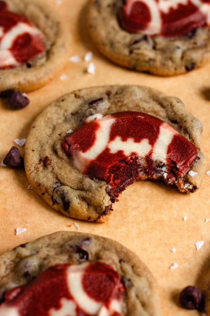 Football cookie with a bite taken out, surrounded by chocolate chips and sea salt.