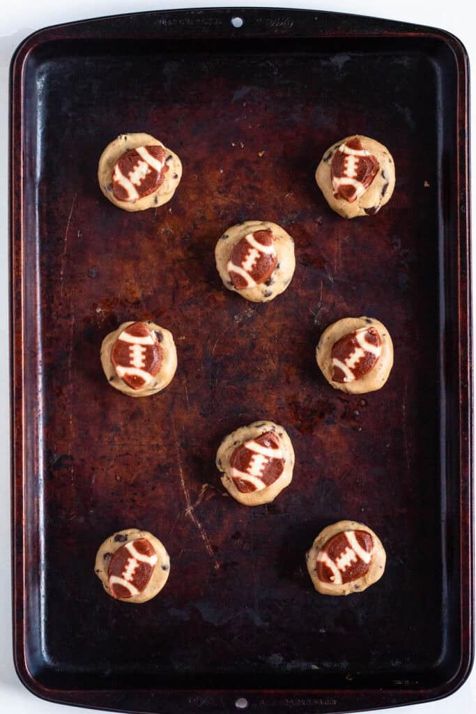 Balls of chocolate chip cookie dough portioned into equal sizes.