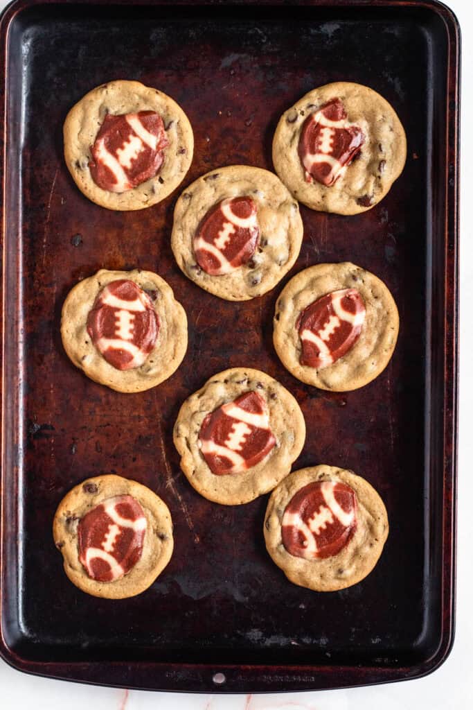 Golden brown football cookies with set edges fresh from the oven.
