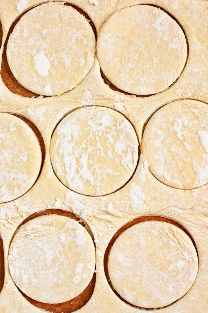 Puff pastry sheets being cut into circles.