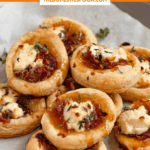 Pinterest image of a parchment-lined plate filled with goat cheese puff pastry bites.