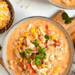 Pinterest image of a top-view shot of a bowl of creamy white bean chicken chili topped with fresh cilantro.