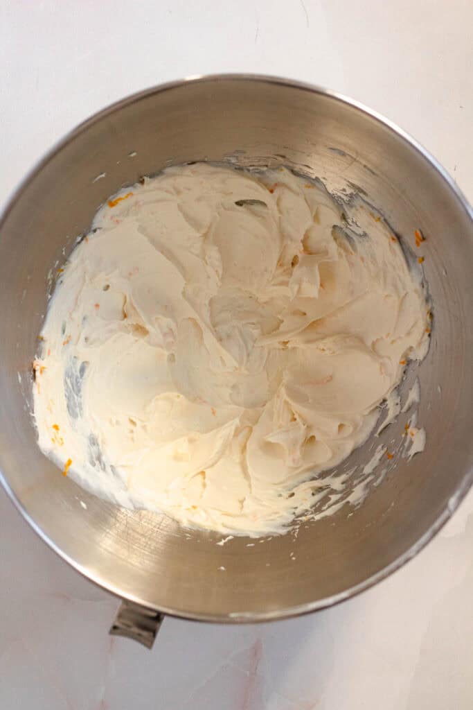 Cream cheese and fresh orange zest mixed together until smooth in a bowl.