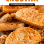 Pinterest image of a close-up of golden crostini slices with crisp edges and lightly seasoned.