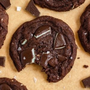 Andes Mint Chocolate Cookies on parchment, with one cookie showing a bite taken out.
