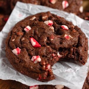 Chocolate Peppermint Cookie with a bite taken out, resting on parchment paper.