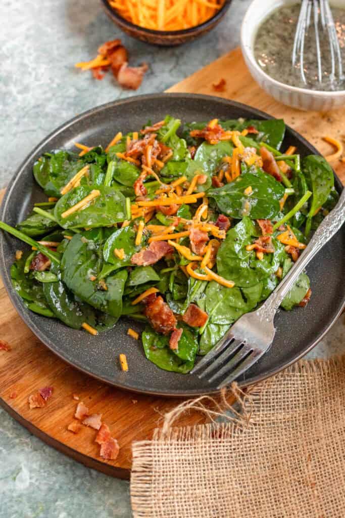 Spinach Salad with Bacon and Sweet Poppy Seed Dressing mixed with cheddar cheese.