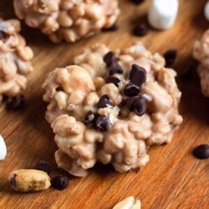 Avalanche cookies with chocolate chips, peanuts, and marshmallows on a wooden surface.