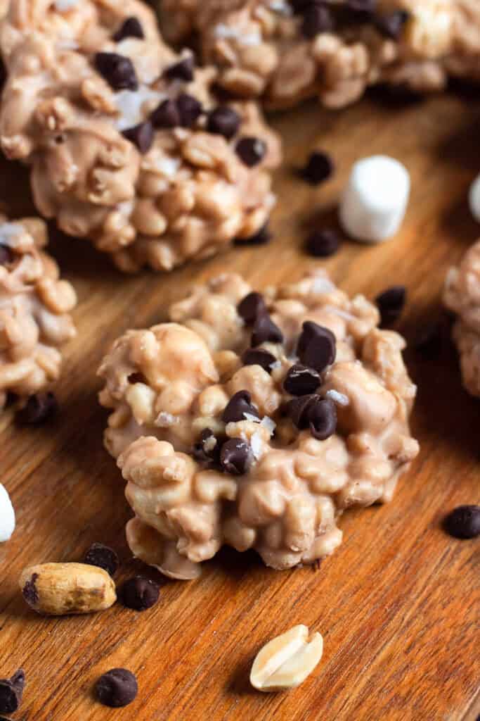 Avalanche cookies with chocolate chips, peanuts, and marshmallows on a wooden surface.