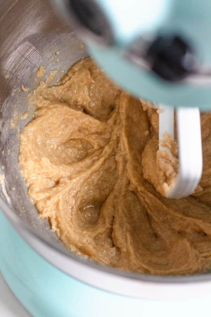 Creamed butter and sugar mixture in a light blue stand mixer bowl.