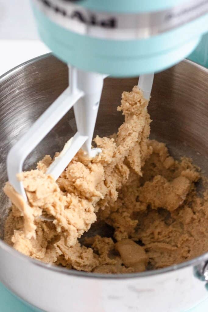 Thick cookie dough being mixed in a stand mixer