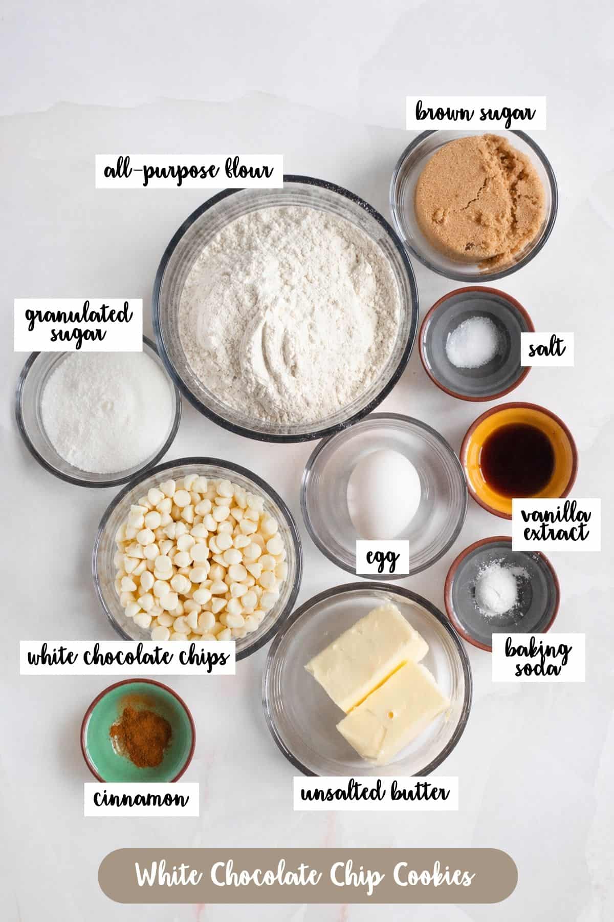 Top-down view of ingredients for white chocolate chip cookies including flour, butter, and chips.