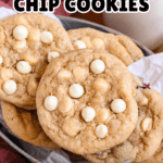 Pinterest image of a top-view shot of white chocolate chip cookies in a parchment-lined silver tin next to a glass of milk.