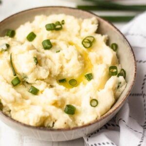 Delicious Horseradish Mashed Potatoes with butter and green onions, perfect for steak dinner.