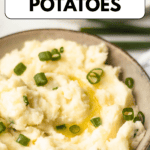 Pinterest image of a bowl of creamy Horseradish Mashed Potatoes topped with melted butter and green onions.