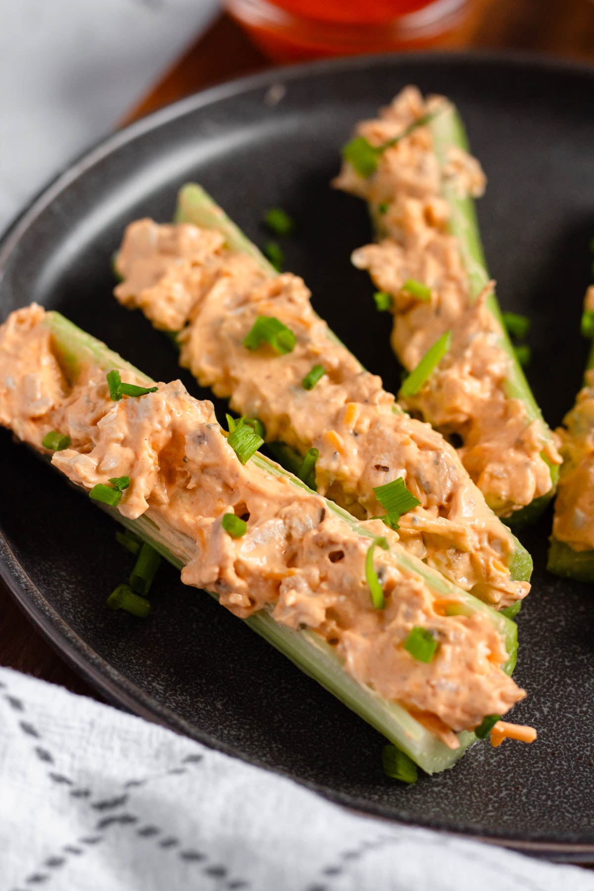 Close up of buffalo chicken stuffed celery on a plate. 