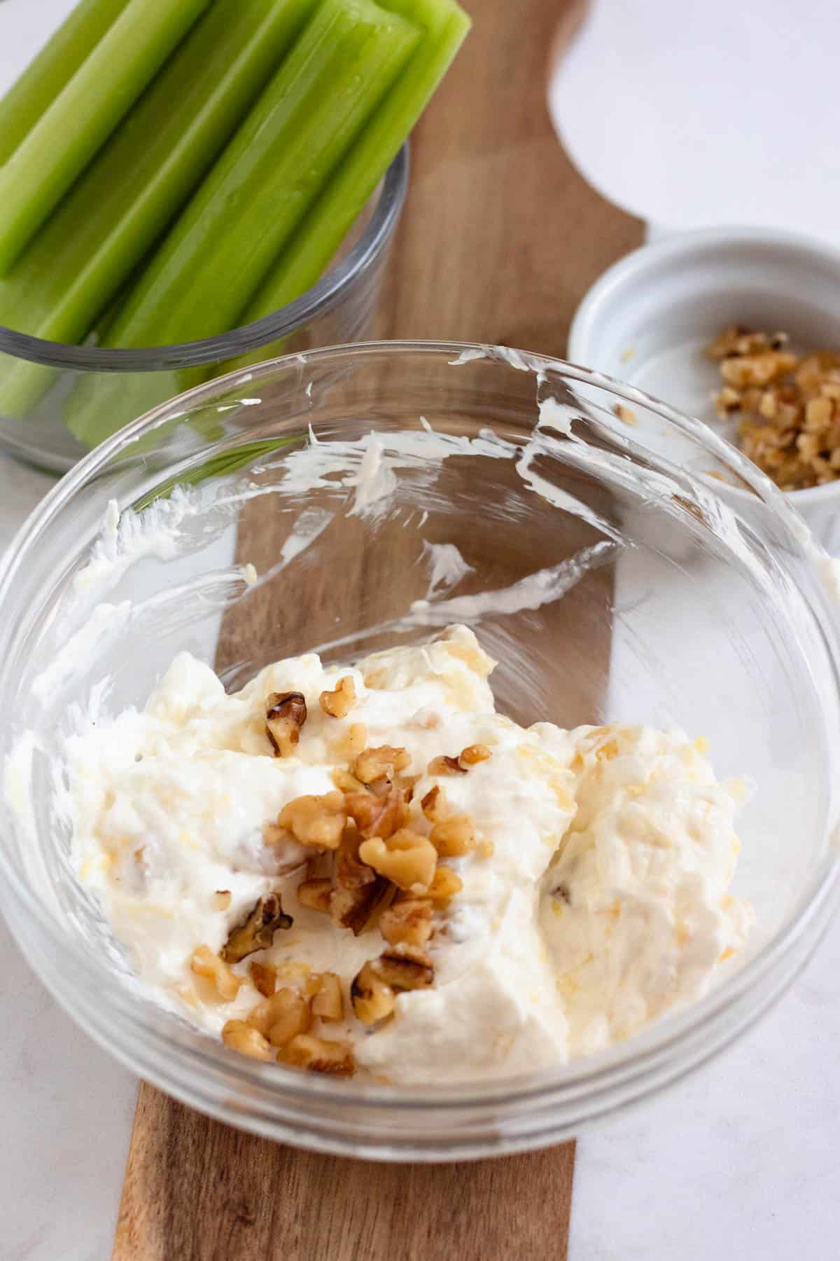 A mixing bowl full of pineapple and walnut cream cheese.