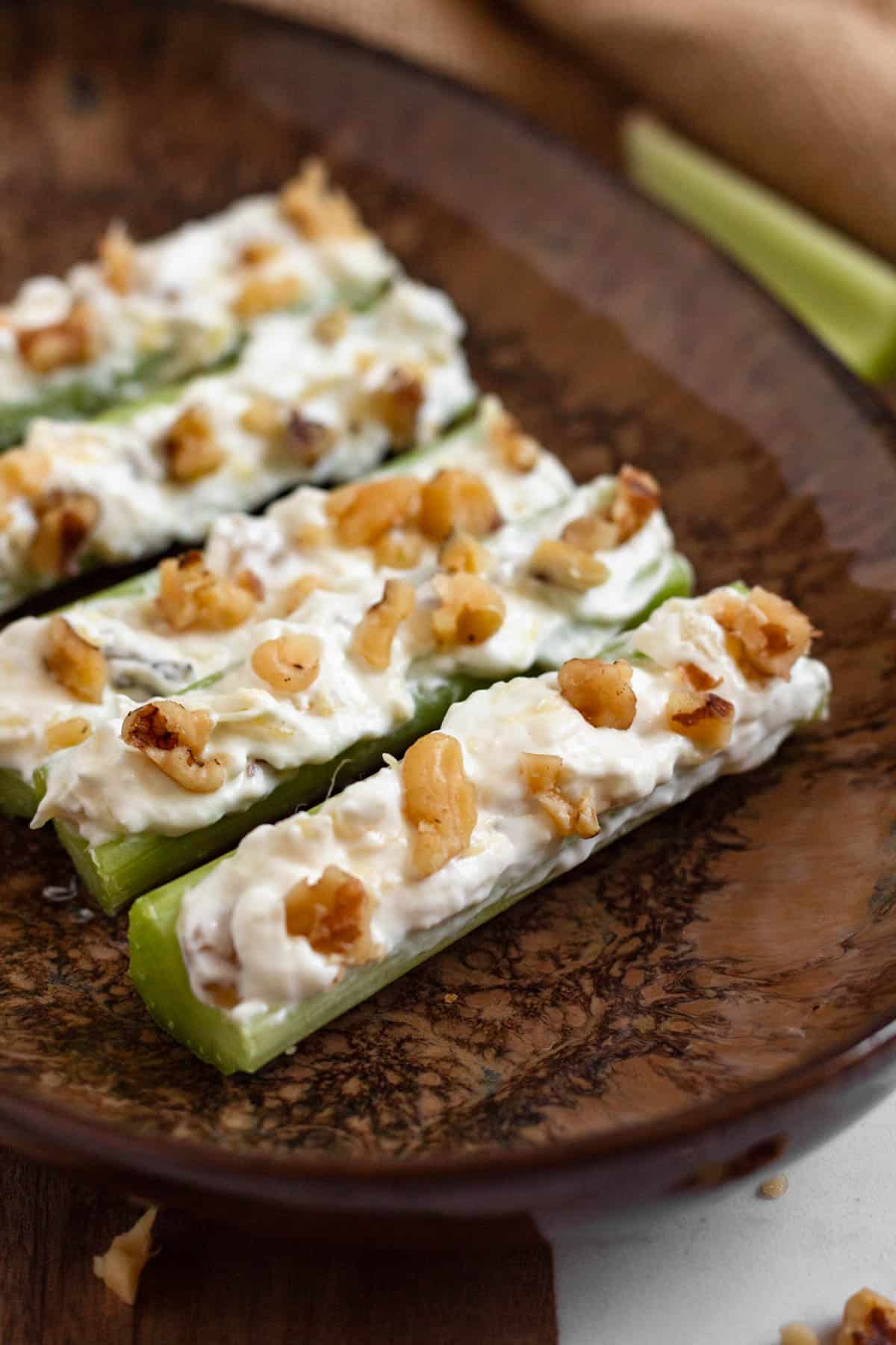 A plate with pineapple walnut filling inside of celery.